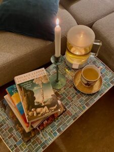 Tisch mit Tee, Büchern und Kerze