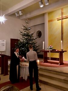 Pastorin und Lektorin vor einem Weihnachtsbaum in einer Kirche