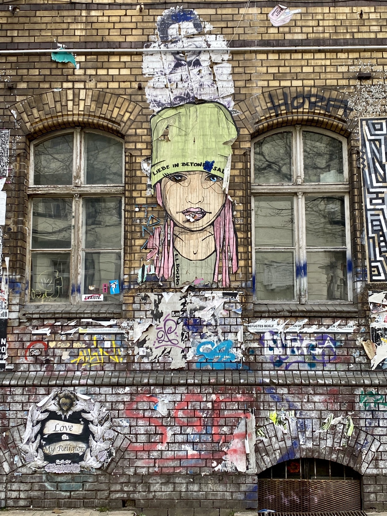 Ein Graffiti an einer Backsteinwand in Berlin mit einem Mädchengesicht