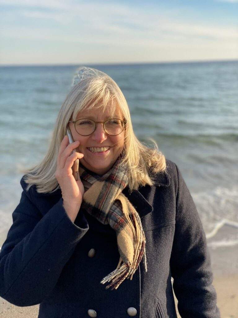 Frau Bachmann telefoniert am Strand